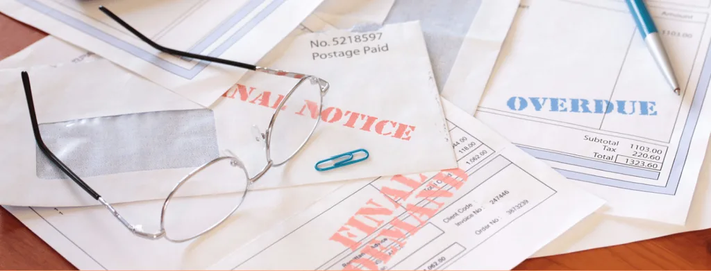 several paper notices on a table with a pair of reading glasses sitting on top